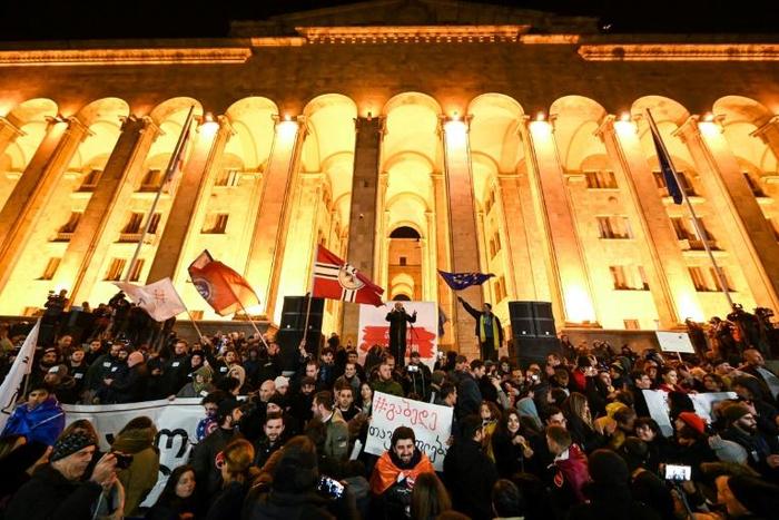 Protesters demanding the government's resignation and early parliamentary polls rally in front of the parliament in Tbilisi