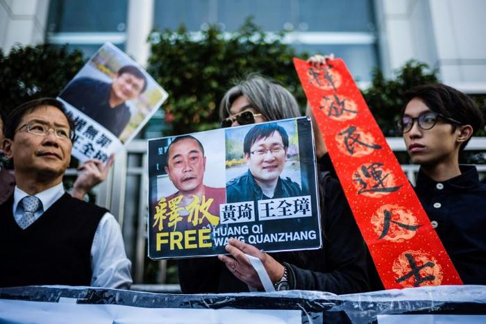 Hong Kong pro-democracy activists attend a protest in support of jailed Chinese human rights lawyer Wang Quanzhang (R on placard) and China's first "cyber-dissident" and founder of human rights website "64 Tianwang", Huang Qi (L on placard)