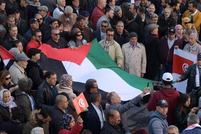 Tunisian demonstrators carry a Palestinian flag during a protest against US President Donald Trump's Middle East peace plan on February 5, 2020