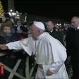 A frame grab taken from a handout video made available by Vatican Media on January 1, 2020 shows a lady (L) grabbing at Pope Francis's hands as he greets Catholic faithful as he arrives to celebrate New Year's Eve mass in Vatican City
