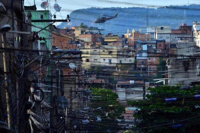 A police helicopter overflies the Favela da Mare shantytown complex in Rio de Janeiro in March 2014 -- the use of helicopters in police raids has increased in recent months