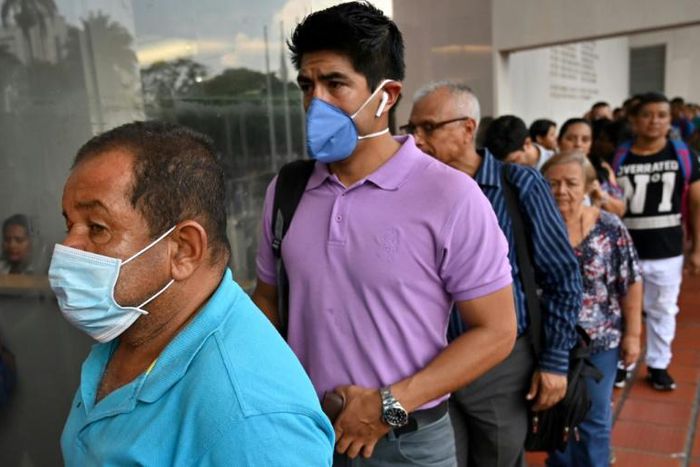 Two men wear protective face masks in Cali, Colombia, on March 12, 2020