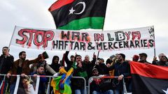 Protesters hold a banner reading "Stop war in Libya, Haftar and mercenaries" during a protest near the chancellery during the Peace summit on Libya at the Chancellery in Berlin on January 19, 2020