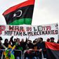 Protesters hold a banner reading "Stop war in Libya, Haftar and mercenaries" during a protest near the chancellery during the Peace summit on Libya at the Chancellery in Berlin on January 19, 2020