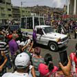 Catholic faithful wearing face masks against the spread of the coronavirus watch the Nazareno de San Pablo motorcade procession to mark Holy Week celebrations in Caracas on April 8, 2020