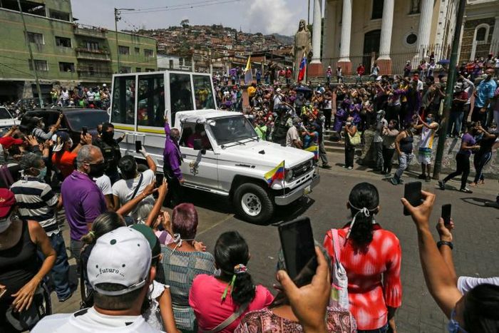 Catholic faithful wearing face masks against the spread of the coronavirus watch the Nazareno de San Pablo motorcade procession to mark Holy Week celebrations in Caracas on April 8, 2020