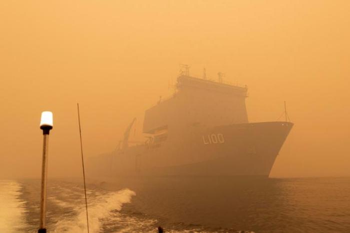 The Royal Australian Navy ship HMAS Choules sails amid heavy smoke off the coast of Mallacoota, Victoria state to assist in bushfire relief efforts