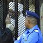 Sudan's deposed president Omar al-Bashir sits in a defendant's cage during his corruption trial in Khartoum on December 14
