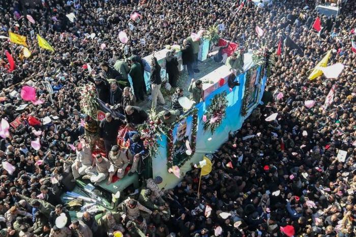 A truck carrying the coffin of slain Iranian general Qasem Soleimani makes its way through a sea of mourners in his hometown Kerman