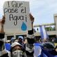 A student carries a sign reading "Let the water pass" during a protest of students and relatives of political prisoners, in Managua on Tuesday