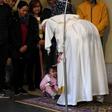 Pope Francis (R) blesses a toddler during an audience with refugees who arrived in Italy from the Greek island of Lesbos