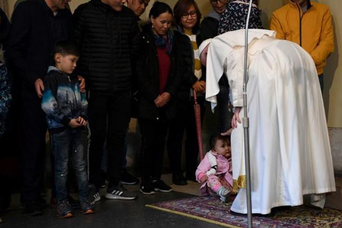 Pope Francis (R) blesses a toddler during an audience with refugees who arrived in Italy from the Greek island of Lesbos