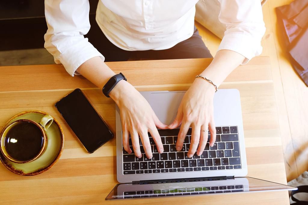 Female entrepreneur Manager using her laptop , working in a cafe or office. Near mobile phone and coffee. Freelance workplace, Breakfast business lady. Search for information on the Internet.