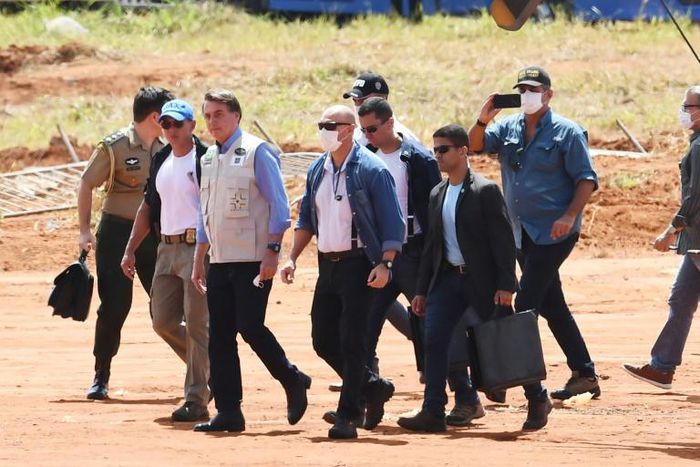 Brazilian President Jair Bolsonaro (3-L), who has scorned social distancing measures to combat COVID-19, is pictured here without a mask as he visits the site of a field hospital under construction in Aguas Lindas, Goias State to handle virus cases