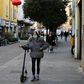 A woman wearing a mask walks in Via Paolo Sarpi, the commercial street in a Chinese district of Milan