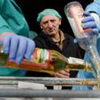 A supervisor looks on as workers empty bottles of the adulterated vodka in the town of Vynnyky, western Ukraine