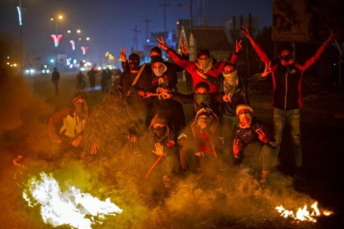 Iraqi anti-government protesters at a makeshift roadblock in the southern city of Basra