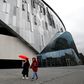 A woman wearing a protective face mask walks near the Tottenham Hotspur Stadium