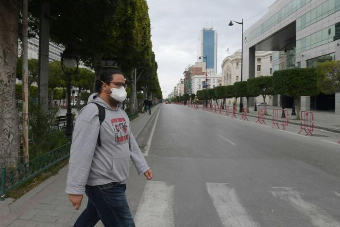 A man wears a face mask to protect against the COVID-19 disease in the Tunisian capital Tunis, where a curfew has already been imposed to stem the spread of the virus