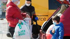 A family ensure they have their masks on as they put shopping in the car in Brunn am Gebirge near Vienna
