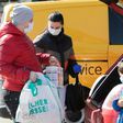 A family ensure they have their masks on as they put shopping in the car in Brunn am Gebirge near Vienna