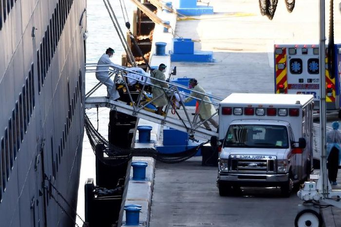 Medics transfer a patient on a stretcher from Holland America's cruise ship Zaandam after it docked at Port Everglades in Fort Lauderdale, Florida