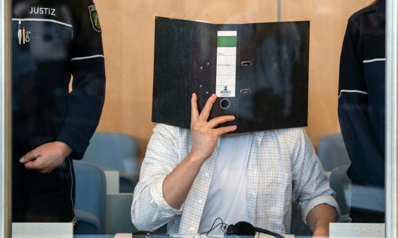 Defendant Sief Allah H. holds a folder in front of his face at the start of his trial on June 7, 2019 at a court in Duesseldorf, western Germany