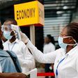 A health worker checks temperature of traveller as part of Coronavirus screening procedure at the Kotoka International Airport