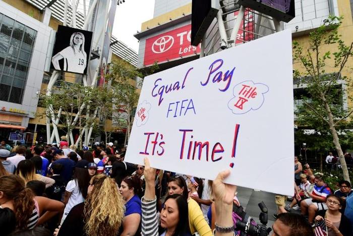 A US women's soccer fan displays a sign calling for equal pay at a rally to celebrate last year's US title run at the Women's World Cup