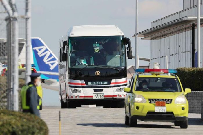 Japanese evacuees are transported by bus after they arrived back in Tokyo from Wuhan