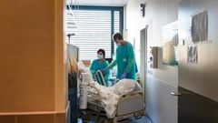 A Swiss soldier (R) helps to move the bed of a COVID-19 patient, at the Pourtales Hospital in Neuchatel on March 25, 2020, after Switzerland deployed its army reservists to relieve hospitals under pressure from the outbreak of COVID-19