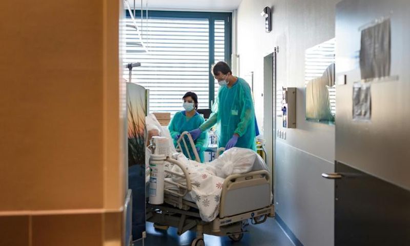 A Swiss soldier (R) helps to move the bed of a COVID-19 patient, at the Pourtales Hospital in Neuchatel on March 25, 2020, after Switzerland deployed its army reservists to relieve hospitals under pressure from the outbreak of COVID-19
