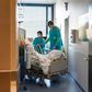 A Swiss soldier (R) helps to move the bed of a COVID-19 patient, at the Pourtales Hospital in Neuchatel on March 25, 2020, after Switzerland deployed its army reservists to relieve hospitals under pressure from the outbreak of COVID-19