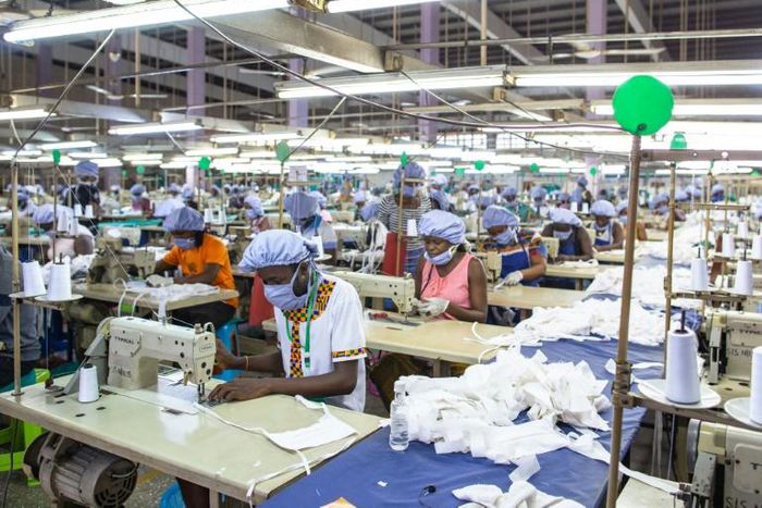 Workers sew personal protective equipment in Ghana, which has lifted a coronavirus lockdown that hit the poor hard