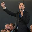 Venezuelan opposition leader Juan Guaido addresses a news conference, flanked by opposition lawmakers and supporters, after being sworn in for a new term as National Assembly leader
