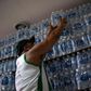 In this file photo taken on January 15, 2020, a man buys bottled water at a liquor store in the Lapa neighborhood of Rio de Janeiro