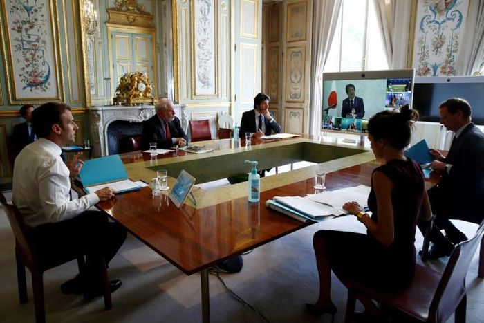 French President Emmanuel Macron (L) attends a videoconference with G7 leaders on coordination of the COVID-19 pandemic response at the Elysee presidential Palace in Paris on April 16, 2020