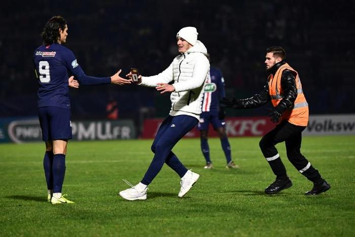 Fan club: A supporter runs towards Paris Saint-Germain's Edinson Cavani during the game at Bondoufle, south of Paris, on Sunday
