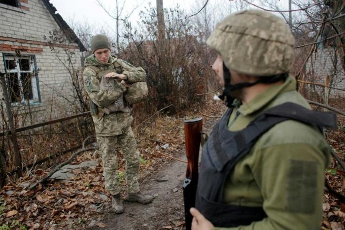 Pondering with concern what concessions to Russia might be forced from their side in summit talks, Ukrainian servicemen patrol near the town of Avdiivka on the frontline with Russia-backed separatists