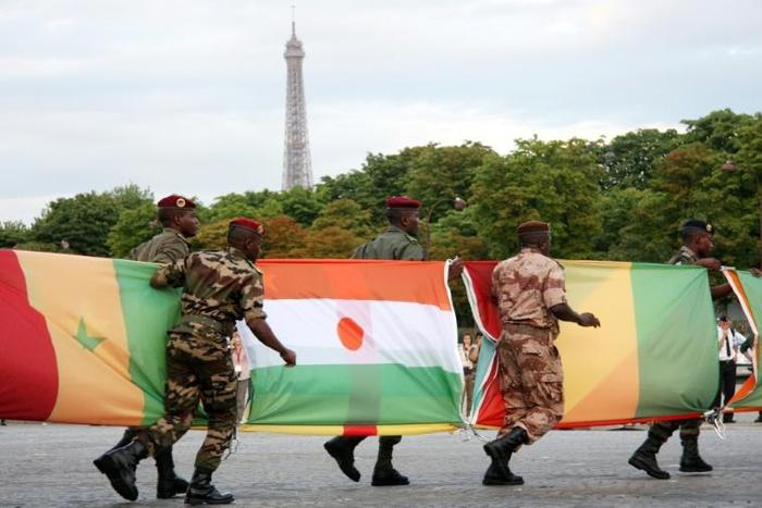 French connection: Troops carry African flags -- with Niger's at centre -- at the 2010 Bastille Day parade in Paris