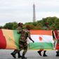 French connection: Troops carry African flags -- with Niger's at centre -- at the 2010 Bastille Day parade in Paris