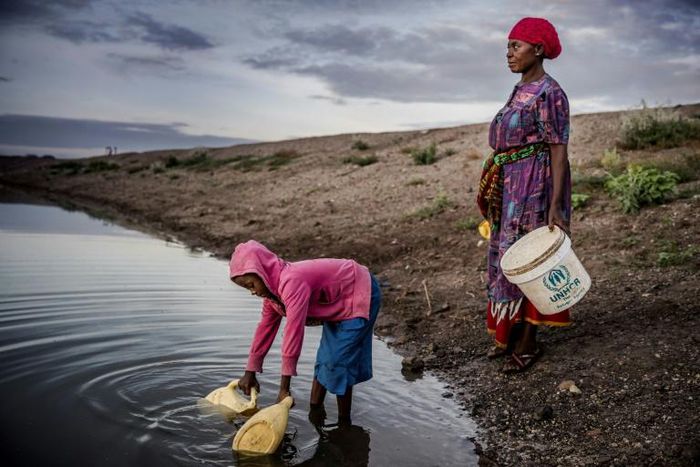 Martha Kasafi and her daughter, refugees from Democratic Republic of Congo, collect water for their crops in Kalobeyei settlement for refugees in  Kenya on October 2, 2019; Independent experts on the Human Rights Committee issued a non-binding ruling i...