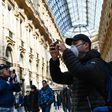 A man wearing a protective facemask takes pictures at the Gallery Vittorio Emanuele II in Milan on Monday