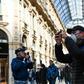 A man wearing a protective facemask takes pictures at the Gallery Vittorio Emanuele II in Milan on Monday