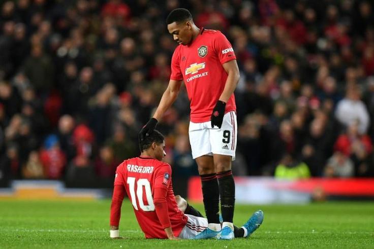 Down and out: Marcus Rashford (bottom) is set to be sidelined for a few weeks by a back injury