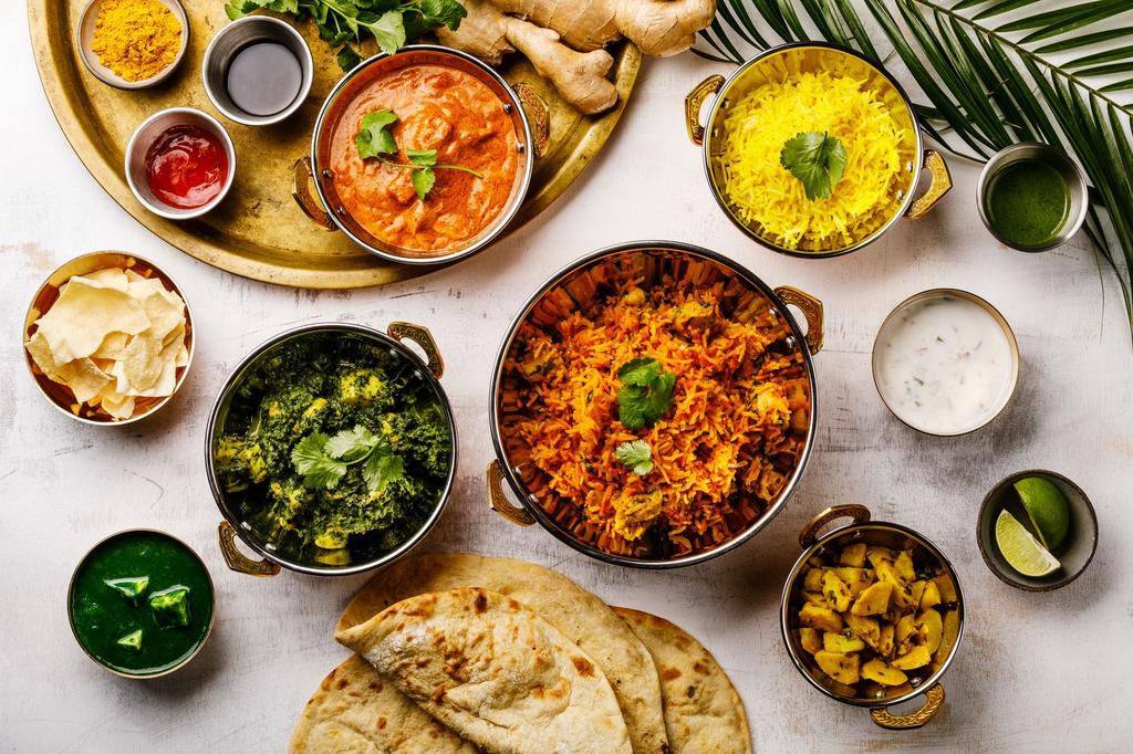 Indian food Curry butter chicken, Palak Paneer, Chiken Tikka, Biryani, Papad, Dal, Rice with Saffron and Naan bread on white background