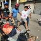 Iraqi demonstrators evacuate a man wounded in clashes with security forces on Baghdad's Martyrs' Bridge (Jisr Al-Shuhada)