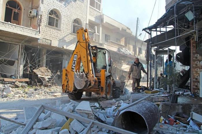 An excavator clears rubble following a reported  air strike in the Syrian town of Saraqib in Idlib province on Saturday