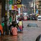 Residents walk through floodwaters past submerged vehicles on a road in the capital Antananarivo
