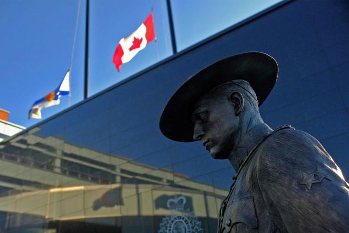 Flags of Nova Scotia and Canada fly at half-staff outside the Nova Scotia Royal Canadian Mounted Police (RCMP) headquarters in Dartmouth on April 19, 2020, after a shooting rampage left at least 20 dead, including an RCMP officer